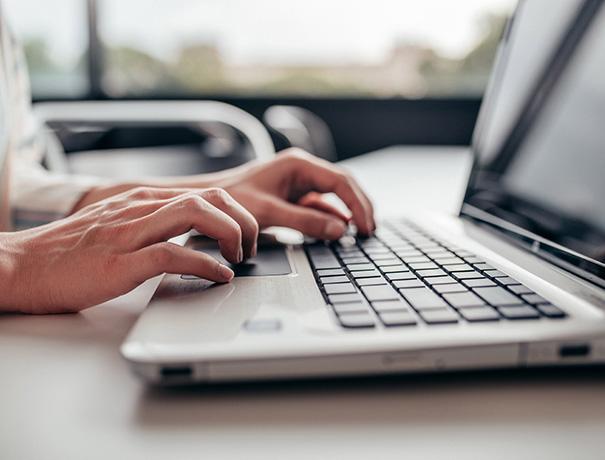 Hands typing on the laptop