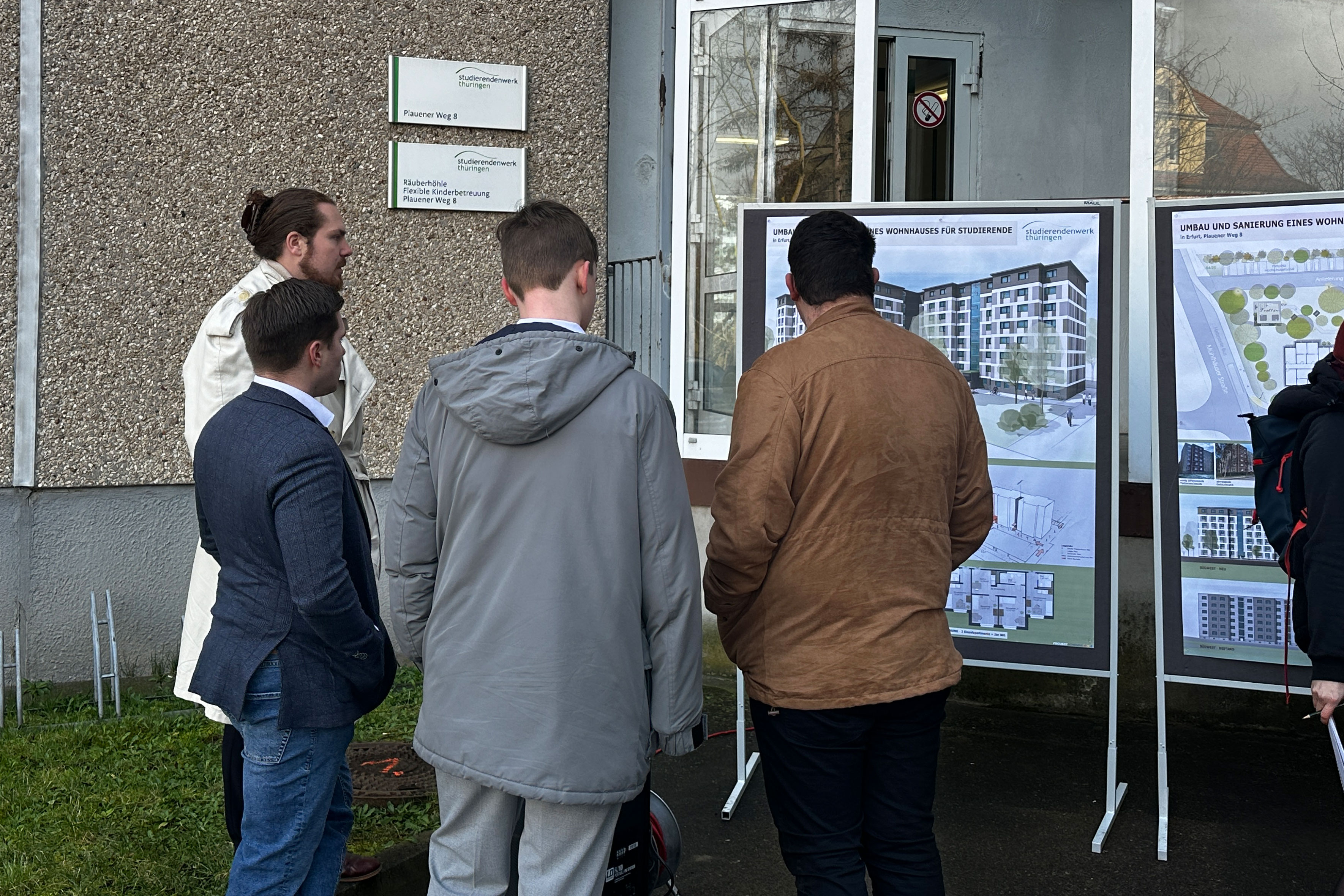 Blick auf die Pläne für die Sanierung. Studierende informieren sich über die künftige Struktur des Wohnheims.