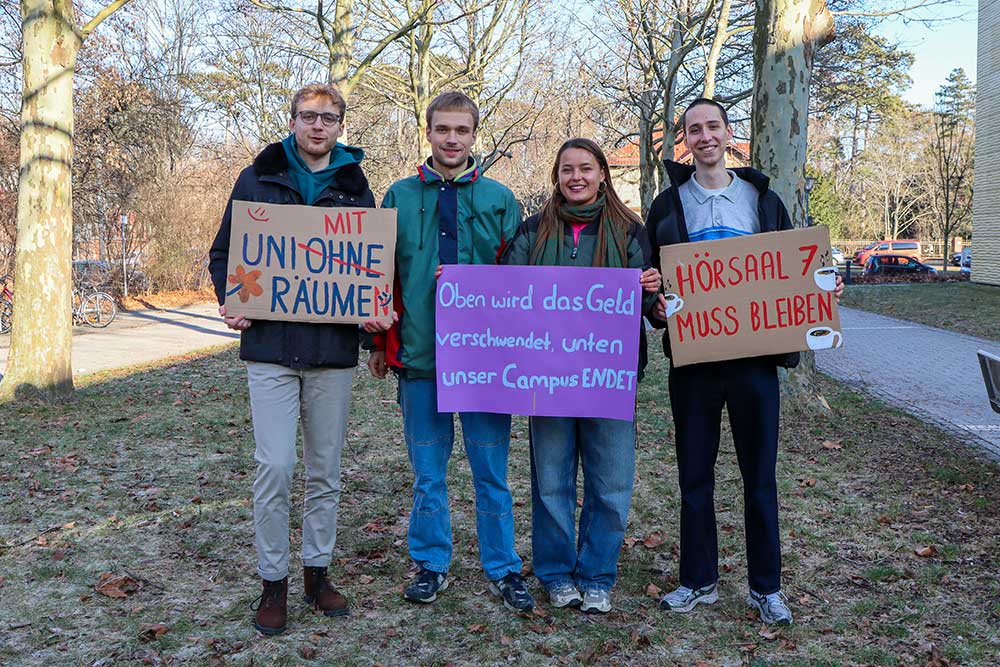 Die Studierenden Felix Heilemann, Benjamin Schick, Franziska Schmitt und Lukas Träger auf dem Campus während der Informationsveranstaltung